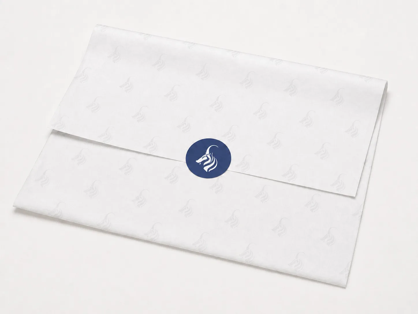 Branded tissue paper, hand-folded and sealed with the wordmark
